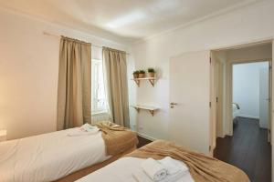 two beds in a small room with a window at Central Oasis Apartment in Cascais