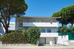 a white house with trees in front of it at Central Holiday Home in Cascais
