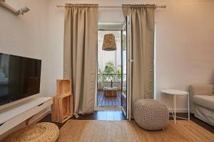 a living room with a flat screen tv and a couch at Central Oasis Apartment in Cascais