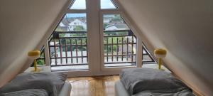a attic room with two beds and a large window at K03 Apartment between Cologne and Bonn in Troisdorf +11 photos