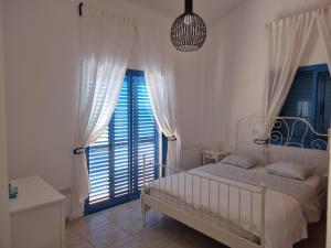 a bedroom with a bed and a large window at Olive Beach Villa in Peyia