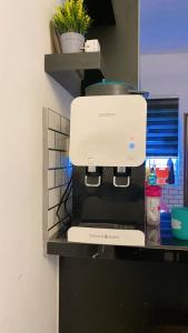 a coffee maker on a shelf in a kitchen at Ammara Homestay PD in Kampong Tanah Merah