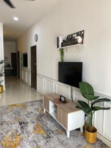 a living room with a flat screen tv on a wall at Ammara Homestay PD in Kampong Tanah Merah