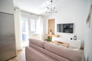 a living room with a couch and a tv at Apartamento SanMartiño con jacuzzi in Tui