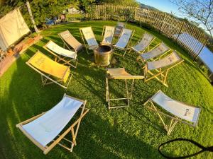 un gruppo di sedie da giardino sedute sull'erba di Bee Happy Farmstay a Podlehnik