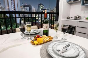 a table with a bottle of wine and wine glasses at Rosemari's Apartments 22 Apartamento Luxuoso in Sao Paulo