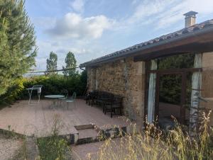 Un patio con mesa y sillas y un edificio. en Gîte de Nirvana, en Figeac