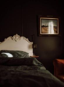 une chambre avec un lit et un tableau au mur dans l'établissement Luxury river cottage, gateway to the East Coast, à Avoca Tasmania