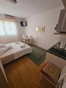 a hotel room with a bed and a table at Apartman Lampić with beautiful sea view in Podgora