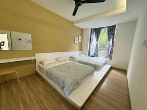 una camera da letto con due letti e una finestra di Eisya Homestay Emerald Avenue Brinchang a Brinchang