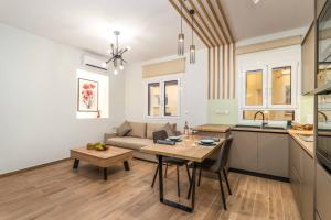 a kitchen and living room with a table and a couch at Coquelicot Appartement in Lefkada Town