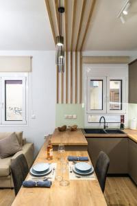 cocina con mesa de madera con sillas y sofá en Coquelicot Appartement, en Lefkada 20 fotos más