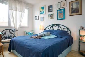 ein Schlafzimmer mit einem blauen Bett mit blauer Decke in der Unterkunft À 2 pas de plage et commerces, jardin & parking in Les Sables-dʼOlonne