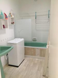 ein Badezimmer mit Toilette und Badewanne in der Unterkunft À 2 pas de plage et commerces, jardin & parking in Les Sables-dʼOlonne