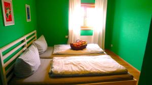 a green bedroom with a bed with a bowl of fruit on it at Haus zum Kranich, traditionelles, charmantes, ehemaliges Bauerngasthaus in Möggers