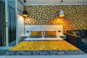a bedroom with a bed and a wall of logs at Квартира на Арбате 1 ком in Shymkent