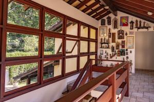 eine Treppe in einem Haus mit großen Fenstern in der Unterkunft Casa Omegna in São Sebastião