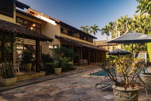 einen Innenhof eines Gebäudes mit einem Regenschirm und Pflanzen in der Unterkunft Casa Omegna in São Sebastião