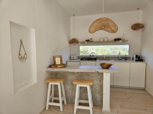 a kitchen with a counter and two stools at White Stone Retreat in Oudtshoorn