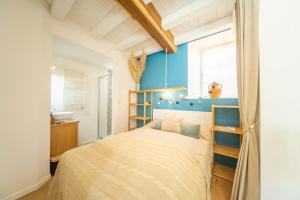 Un dormitorio con una cama con una pared azul. en Chaumière des Dunes à 350m de la plage de Kerhillio, en Erdeven