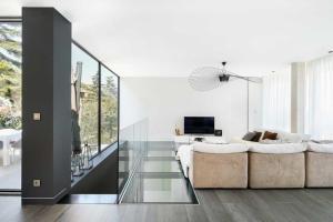 a white living room with a couch and a tv at maison in Casablanca