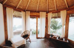 a living room with large windows and a chair at สะปัน Riva camp in Ban Huai Ti