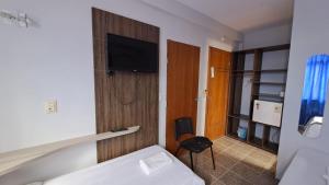 a hotel room with a bed and a tv on the wall at Hotel Blue Star II in Foz do Iguaçu