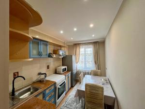 a small kitchen with a sink and a table in it at sairan comfort in Almaty