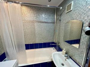 a bathroom with a tub and a sink and a mirror at sairan comfort in Almaty +8 photos