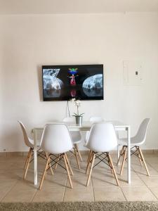 a dining room with a table and four chairs at Boulevard Park IV 104 in Mayaguez +5 photos