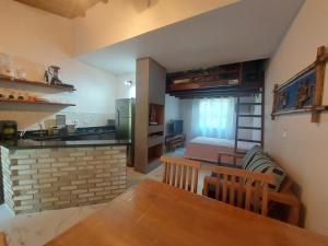a kitchen and a living room with a dining table and a room with a bed at Flat Maresias in São Sebastião +12 photos