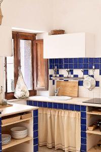 eine Küche mit einem Waschbecken und einer blau gefliesten Wand in der Unterkunft La Ripa-apartment on the cliff edge in Peschici