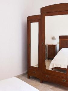 ein Schlafzimmer mit einem großen Spiegel neben einem Bett in der Unterkunft La Ripa-apartment on the cliff edge in Peschici