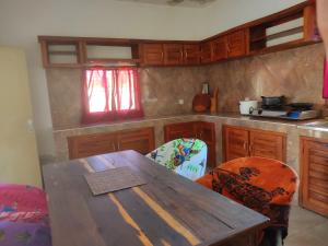a kitchen with a wooden table and chairs at Bemaso in Toliara
