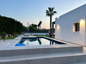 a swimming pool in the backyard of a house at Elsa Holiday Home in Fontane Bianche