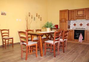 a kitchen with a wooden table and chairs at Santa Ittoria in Cossoine