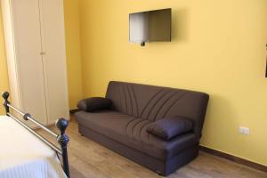 a couch in a room with a tv on the wall at Santa Ittoria in Cossoine