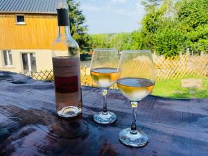 two glasses of white wine sitting on a wooden table at la maison Massonat in Cossaye