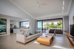 リヴィエール・ノワールにあるLuxury Penthouse River Mouth Views & Poolsのソファとテーブルのあるリビングルーム