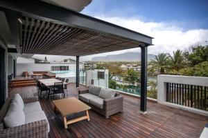 リヴィエール・ノワールにあるLuxury Penthouse River Mouth Views & Poolsの家の上にソファとテーブル付きのデッキ
