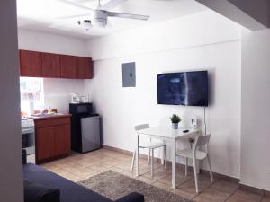 a kitchen with a white table and a small kitchen with a refrigerator at Boulevard Park IV 202 in Mayaguez