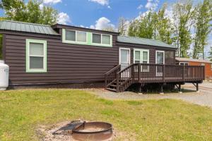 a house with a deck and a grill in the yard at Jellystone Park Birchwood Acres in Greenfield Park
