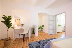 a white bedroom with a desk and a bed at BartApart in Kutná Hora +4 photos