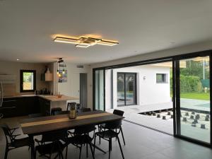 a kitchen and dining room with a table and chairs at Villas-des-oyats - Arena - 8 personnes climatisée piscine chauffée in Seignosse