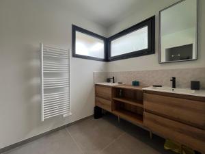 a bathroom with two sinks and a mirror at Villas-des-oyats - Arena - 8 personnes climatisée piscine chauffée in Seignosse +9 photos