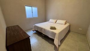 a bedroom with a bed with two pillows and a window at La Martina in Esquina +1 photo