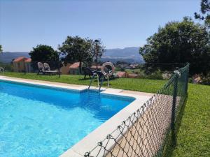 a swimming pool with a fence around it at Apartamento Miravalles in Muros de Nalón