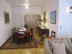 sala de estar con mesa de comedor y perro en Apartamento Vista Mar - 2 Garagens, en Guarujá