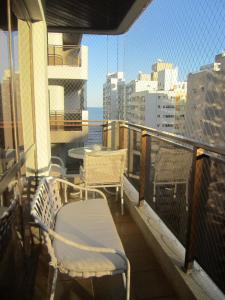 a balcony with a table and chairs on a building at Apartamento Vista Mar - 2 Garagens in Guarujá