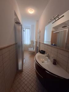 un bagno con lavandino, water e specchio di GIULIA e ANDREA a Bellano